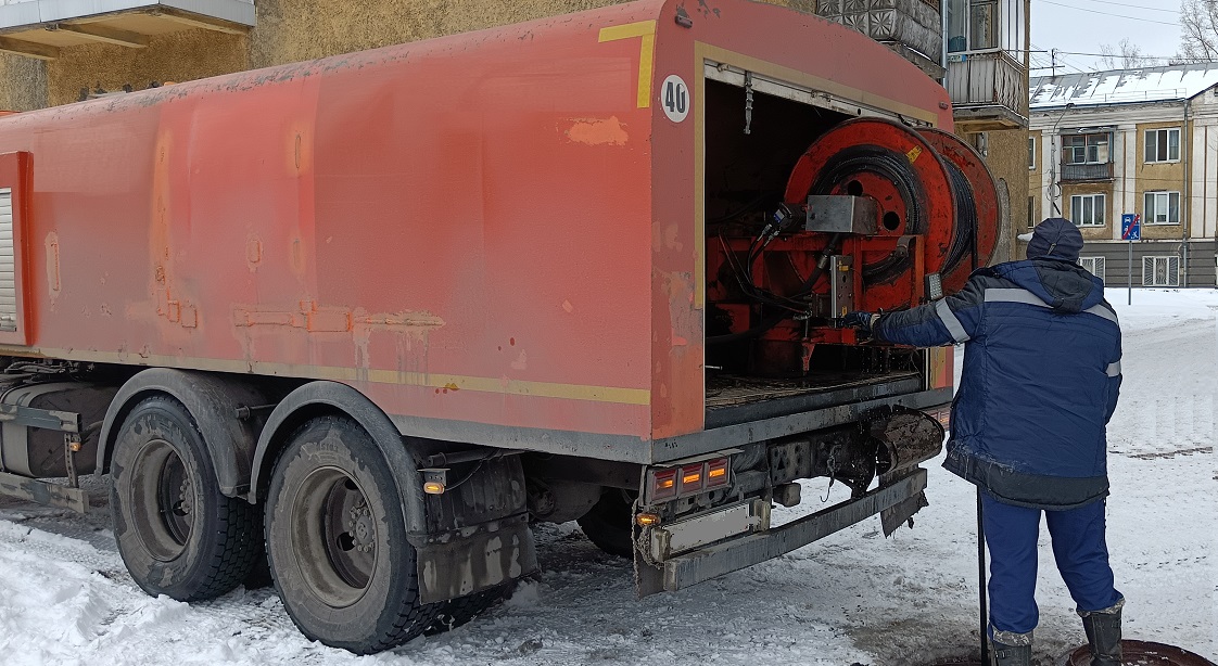 Каналопромывочная машина и работник прочищают засор в канализационной системе в Черкесске