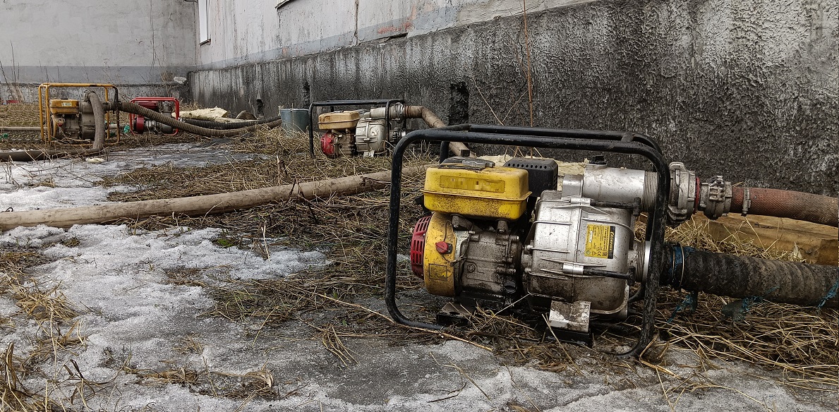 Откачка мотопомпами талой воды из подвала дома в Карачаево-Черкесии